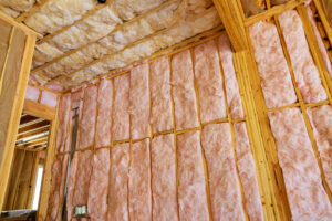 Pink fiberglass insulation in wooden framing